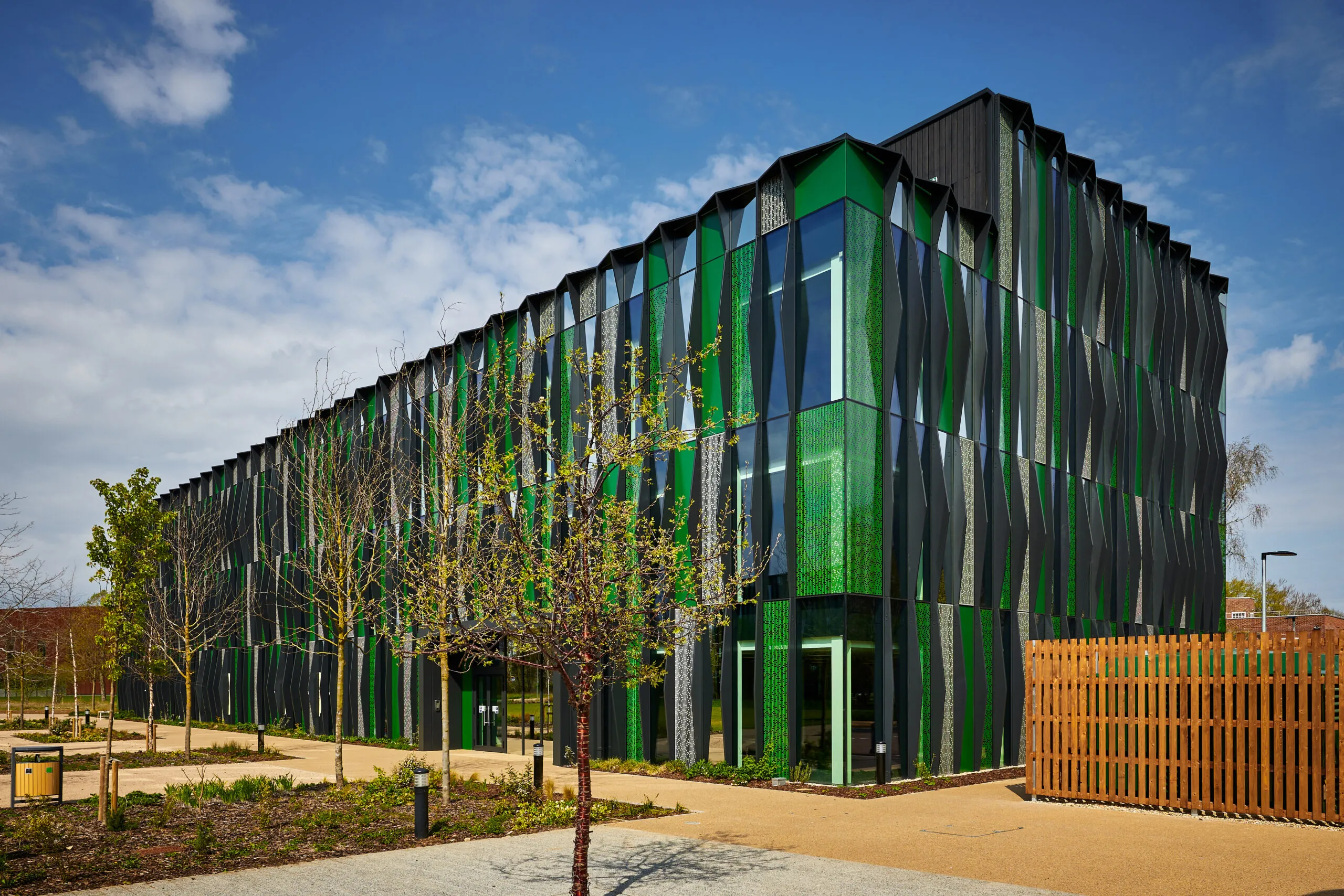 UKSA’s new headquarters – a modern green and blue glass building surrounded by trees and fencing – on the Harwell Campus, Oxfordshire.