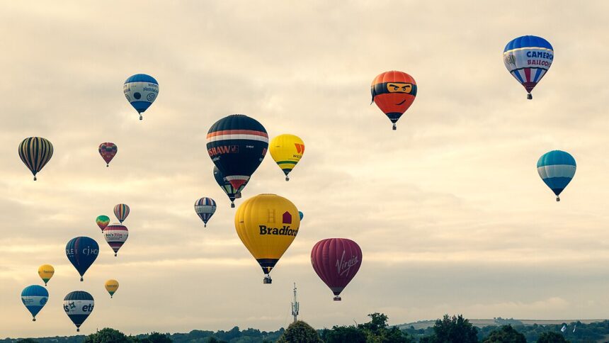 Image shows many hot air balloons in a dusky sky in 2015 at the 2025 Bristol International Balloon Fiesta