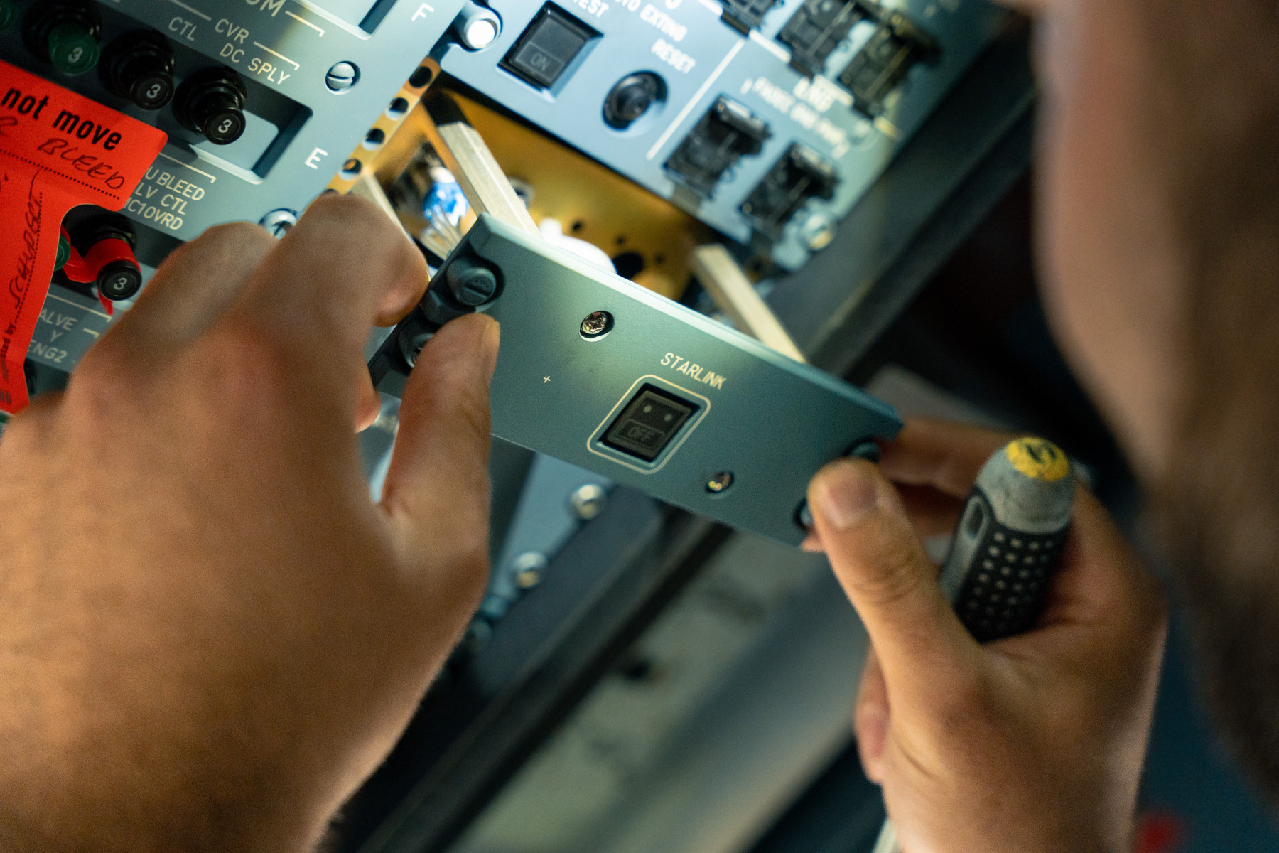 A close up shot of hands holding a screwdriver installing equipment