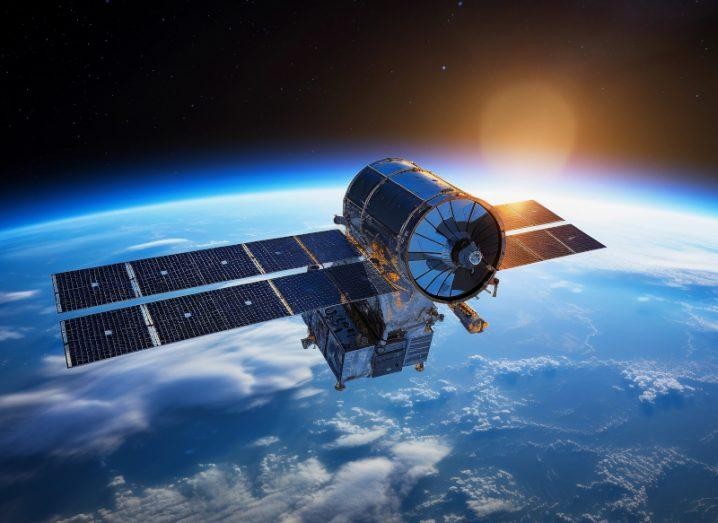 An artist’s impression of one of Spire’s EURIALO satellites, a large cylinder connected to a silver box with solar panels extending from the main body, orbiting above Earth.