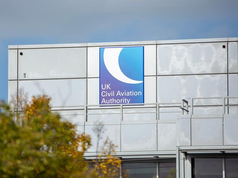 A blue and white Civil Aviation Authority sign on the side of a grey building in Gatwick, UK.