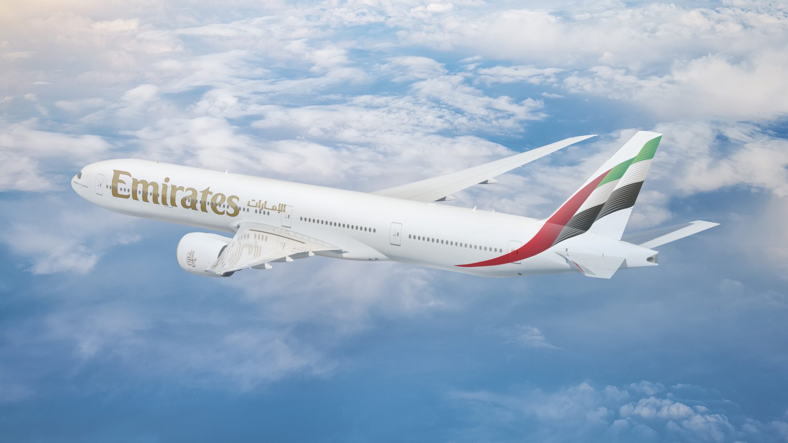 Photograph depicting the exterior overview of the Boeing 777 flying above the clouds.