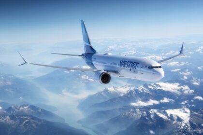 An WestJet Boeing 737-8 MAX aircraft flying above rocky mountains
