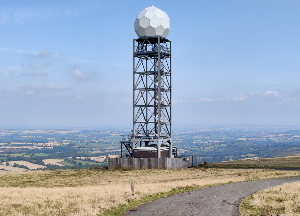 A Met Office weather radar station consisting of a large grey ball with hexagonal faces atop a tall truss structure.