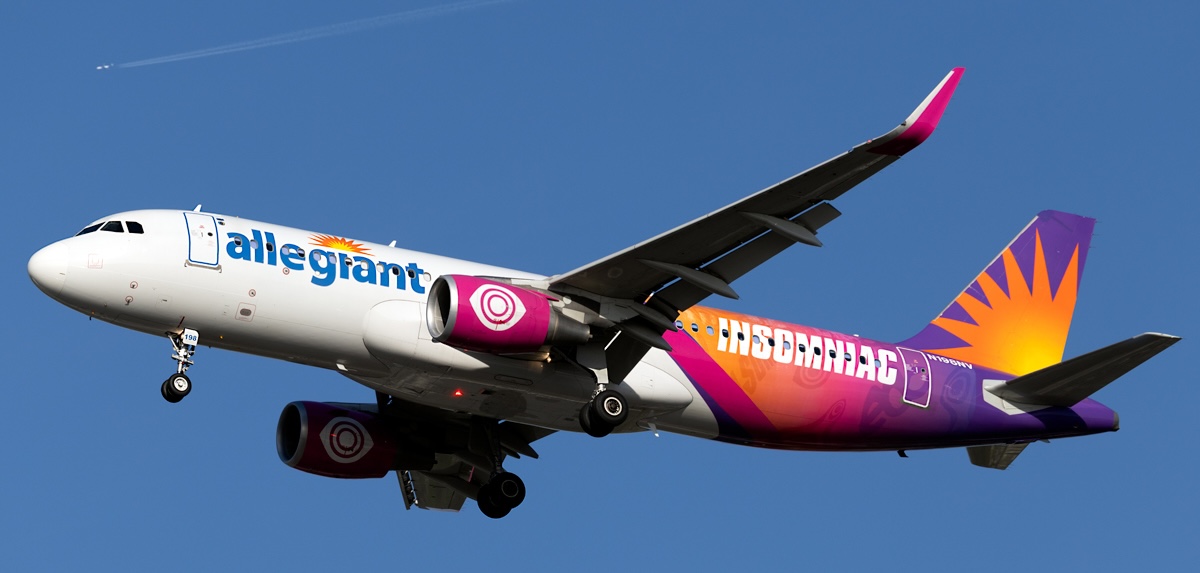 Full length side view of Allegiant Air's A320-214 (registration N198NV) mid-air with its landing gear still extended.