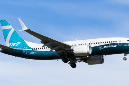 A full-length side view of Boeing's 737 MAX 7 (registration N7201S) in the air with its landing gear still extended.