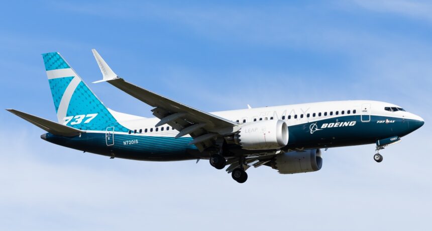 A full-length side view of Boeing's 737 MAX 7 (registration N7201S) in the air with its landing gear still extended.