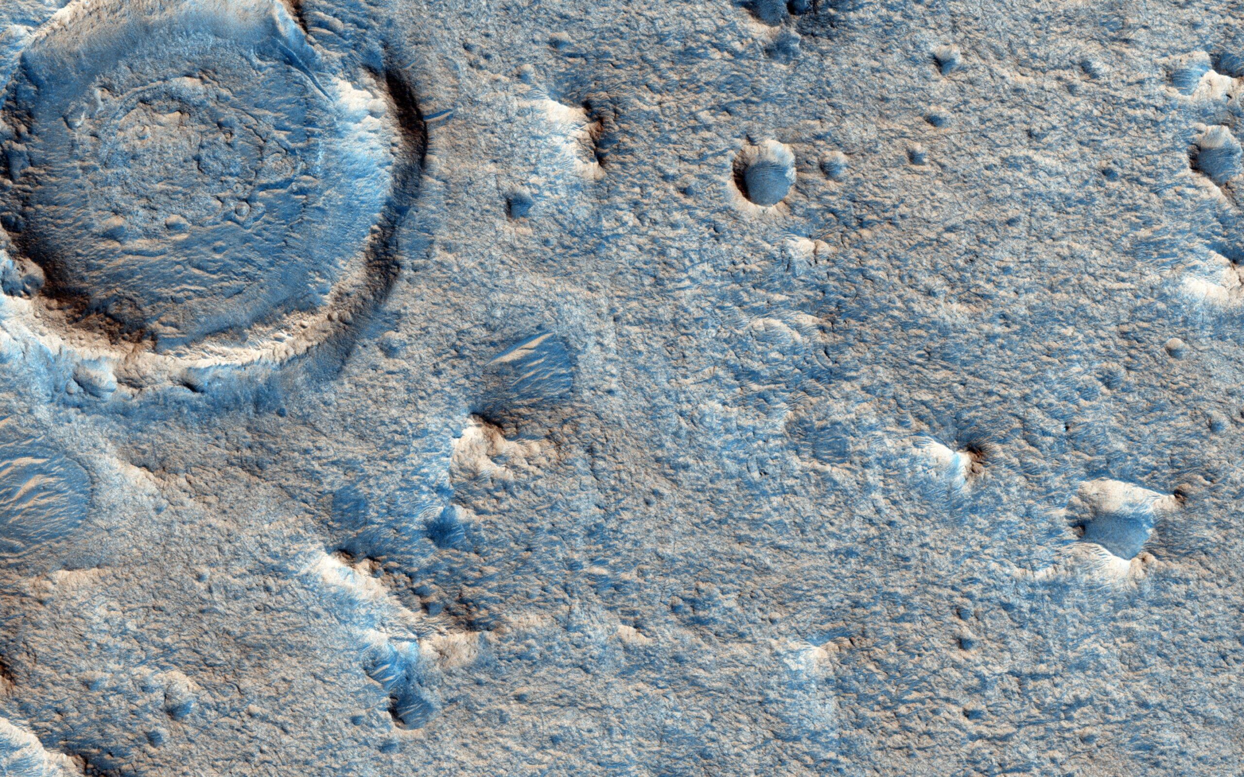 An aerial view of Mars’ Oxia Planum, featuring some mountains and craters in an otherwise flat landscape which lends itself as a candidate for Rosalind Franklin’s landing site, as seen from the Mars Reconnaissance Orbiter.
