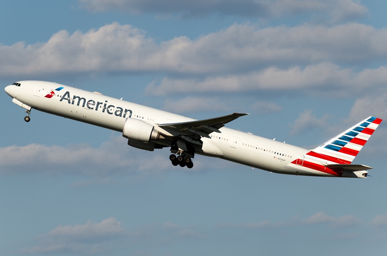 American Airlines' Boeing 777-323ER (registration N733AR) in the sky during take off with its landing gear still extended.