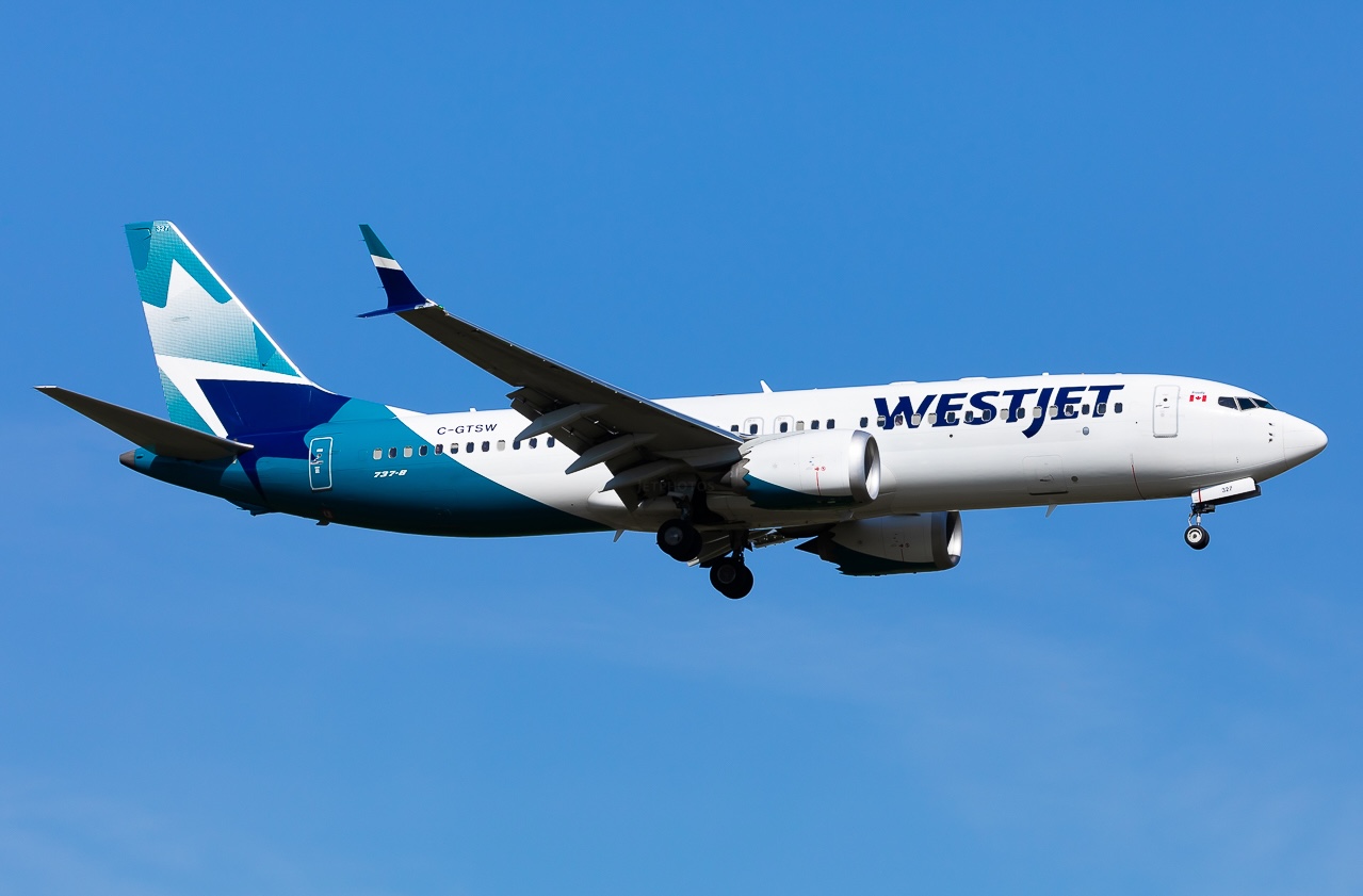 A full-length side view of Boeing's 737 MAX 8 (registration C-GTSW) in the air with its landing gear still extended.