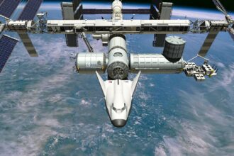 Artist’s impression of the Dream Chaser spaceplane, which has a futuristic, streamlined, bulbous aircraft shape, docked to the ISS, a large satellite with many gantries and solar panels, orbiting above the ocean on Earth.