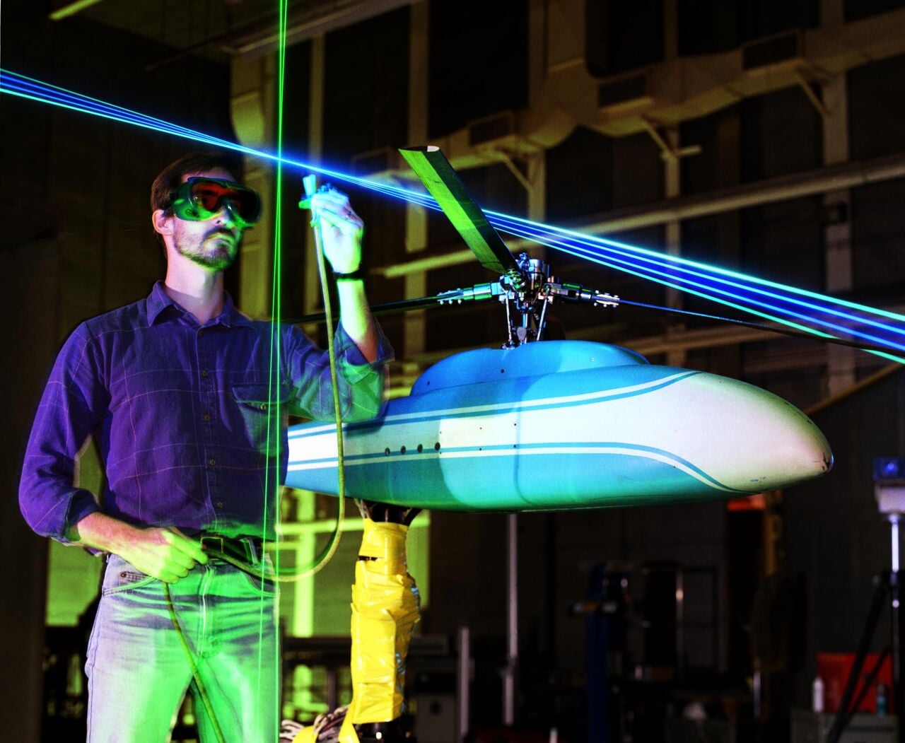 A scientist uses lasers to study the shape of a helicopter model inside the 14- by 22-Foot Subsonic Wind Tunnel at NASA Langley.