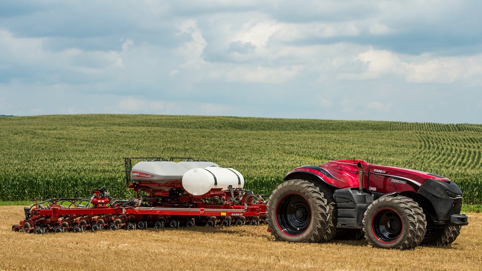 The Case IH Magnum Autonomous Tractor – a red vehicle with large tyres and no cab - in a field with a planter implement.