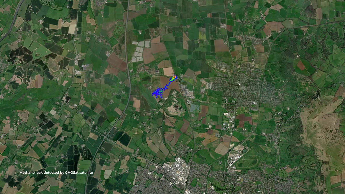 A blue and red area at the centre of a satellite image, which otherwise depicts fields and several large towns seen from above, highlights a methane leak from a faulty pipe in Cheltenham.
