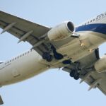 An El Al Boeing 767-300ER (registration 4X-EVO) photographed from below with its landing gear fully extended, showing the aircraft's underbelly, wing structure, and the prominent blue Star of David on the tail against a clear blue sky.