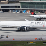 Air Canada fleet positioned on the runway ready for take-off at a busy airport