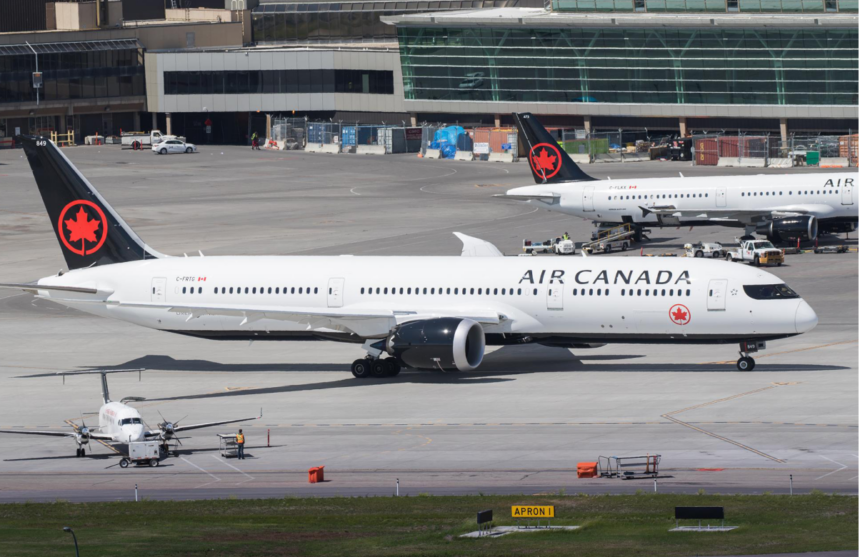 Air Canada fleet positioned on the runway ready for take-off at a busy airport