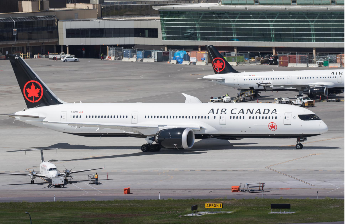 Air Canada fleet positioned on the runway ready for take-off at a busy airport