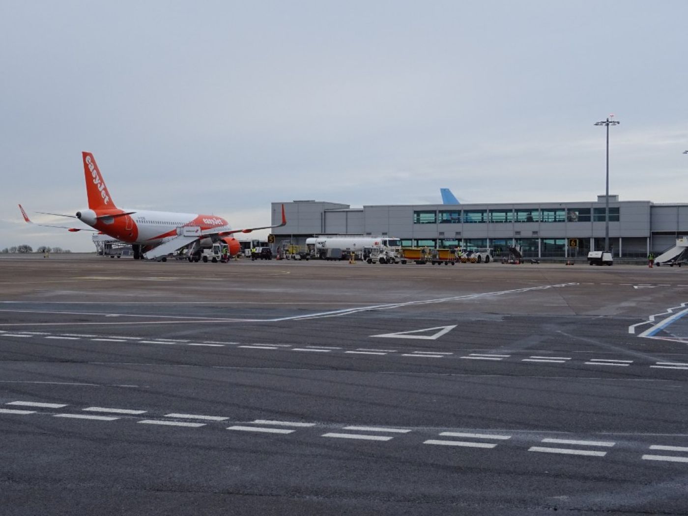 An image of Bristol Airport's runway with a back view of a stopped EasyJet aircraft, the terminal can be seen in the horizon with a blue sky