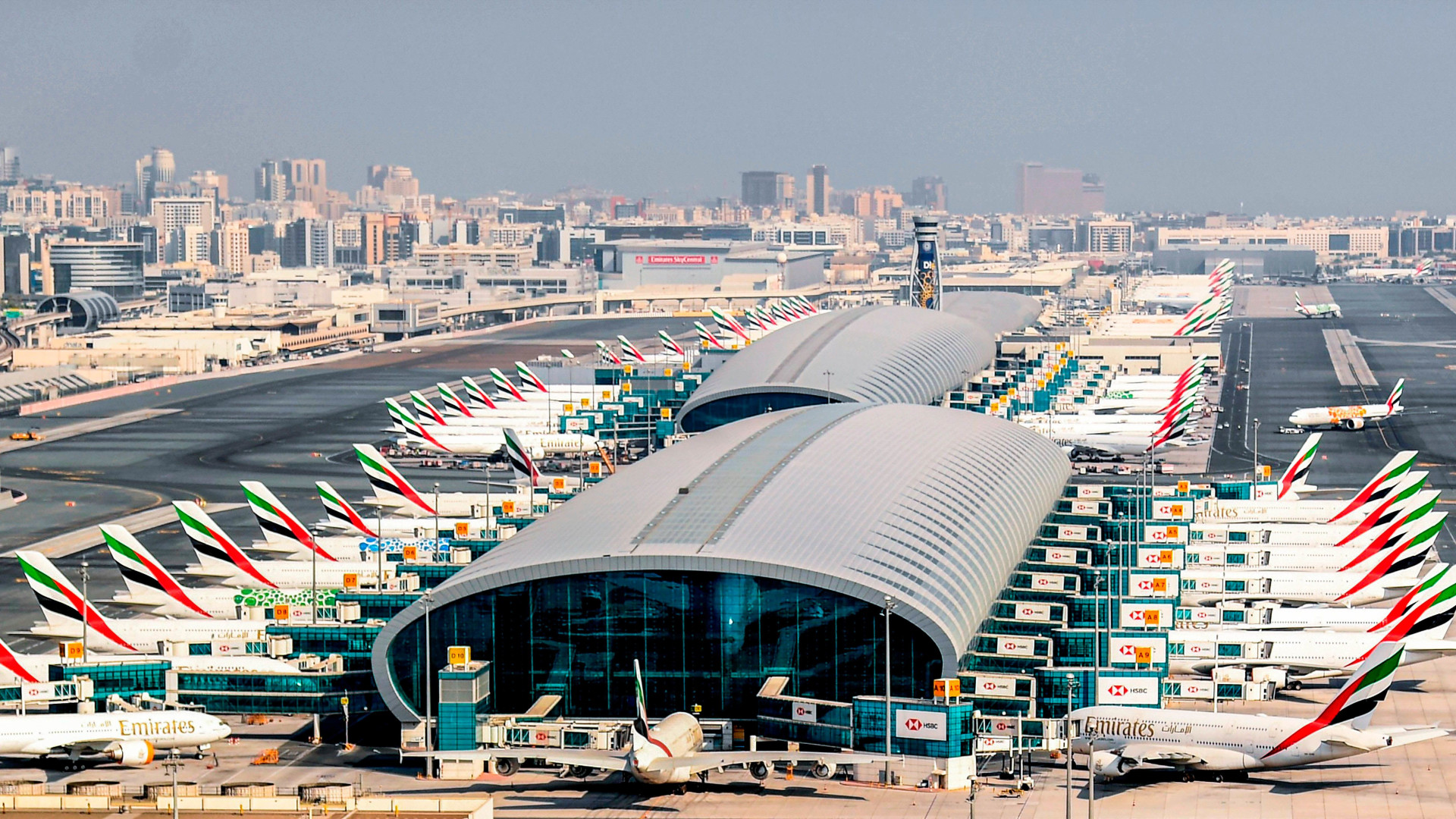 Photograph depicting Emirates aircraft lined up on the runway at DXB, Terminal 3. 
