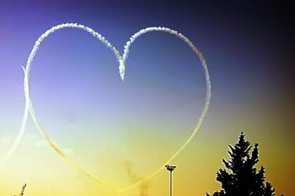 Image shows a heart shaped aircraft trail in a colourful Cyprus sky
