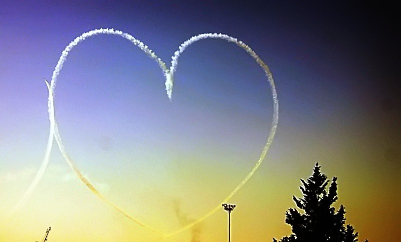 Image shows a heart shaped aircraft trail in a colourful Cyprus sky