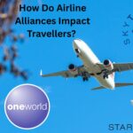 The logos of three airline alliances: Star alliance, SkyTeam, and Oneworld, superimposed on a picture of a plane flying upwards in front of a blue sky. There is a tree to the left of the image, and text saying “How Do Airline Alliances Impact Travellers?”