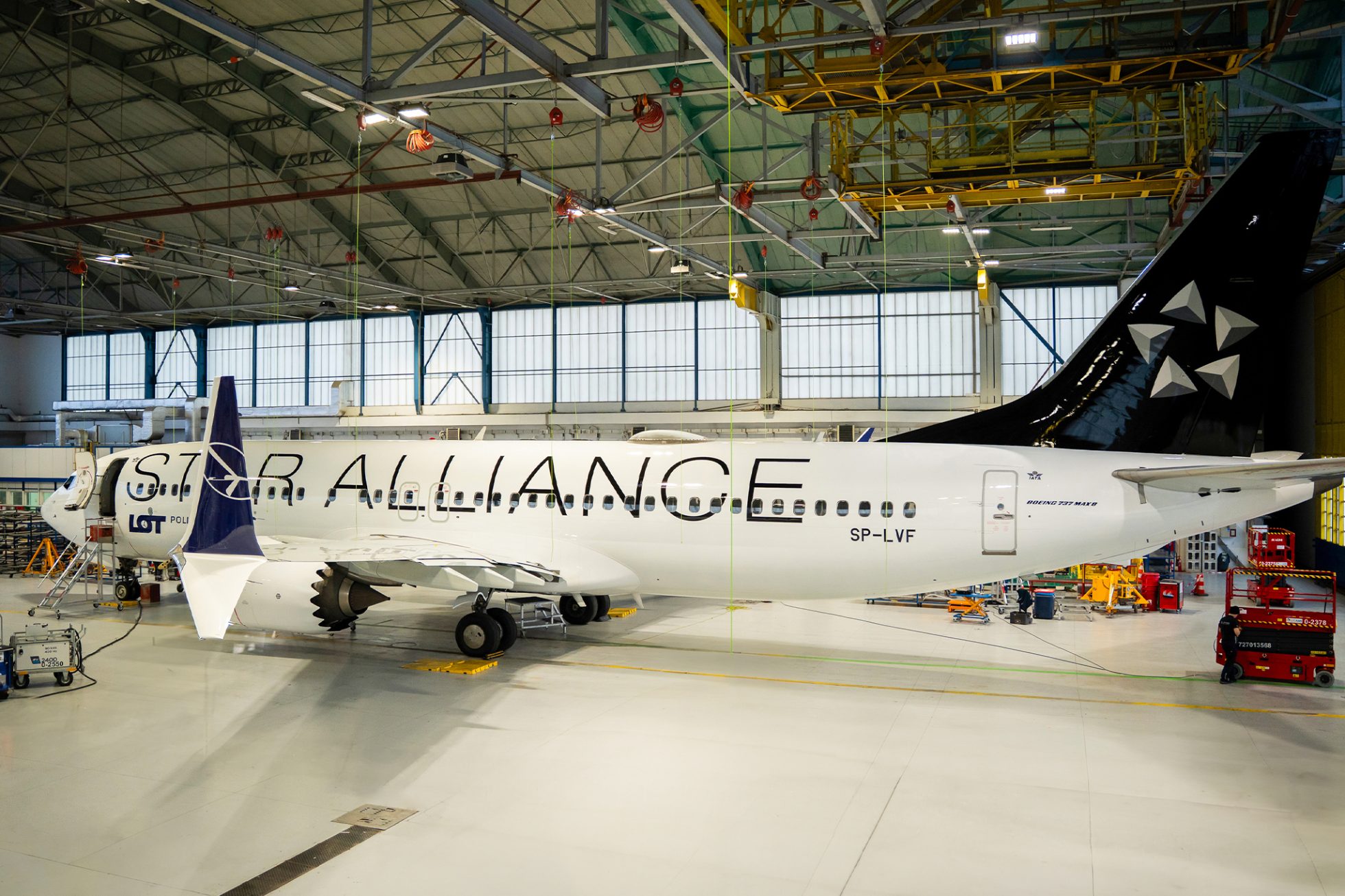 A jet painted in a black and white Star Alliance livery sitting in a hanger. The alliance’s logo is painted on its tail.