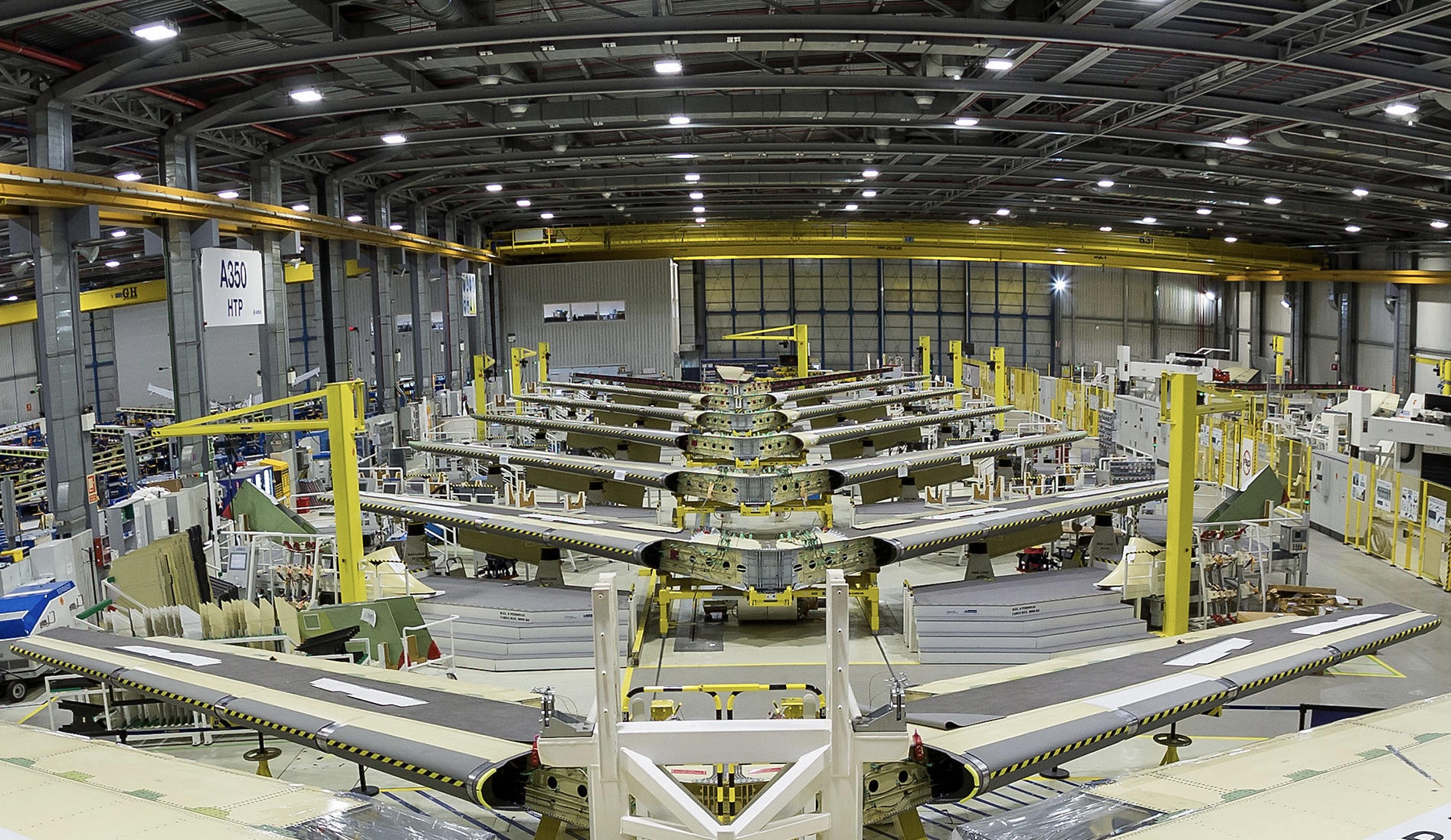 The inside of an Airbus factory in the UK. A row of Airbus A350 tails are seen inside a large warehouse.