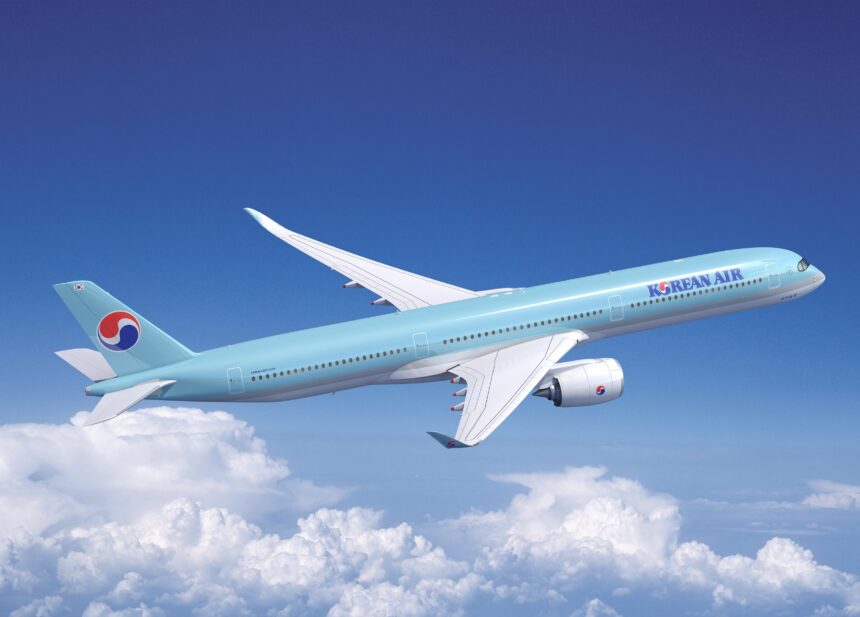 A blue and white Korean Air jet flying upwards in front of a cloudy sky.