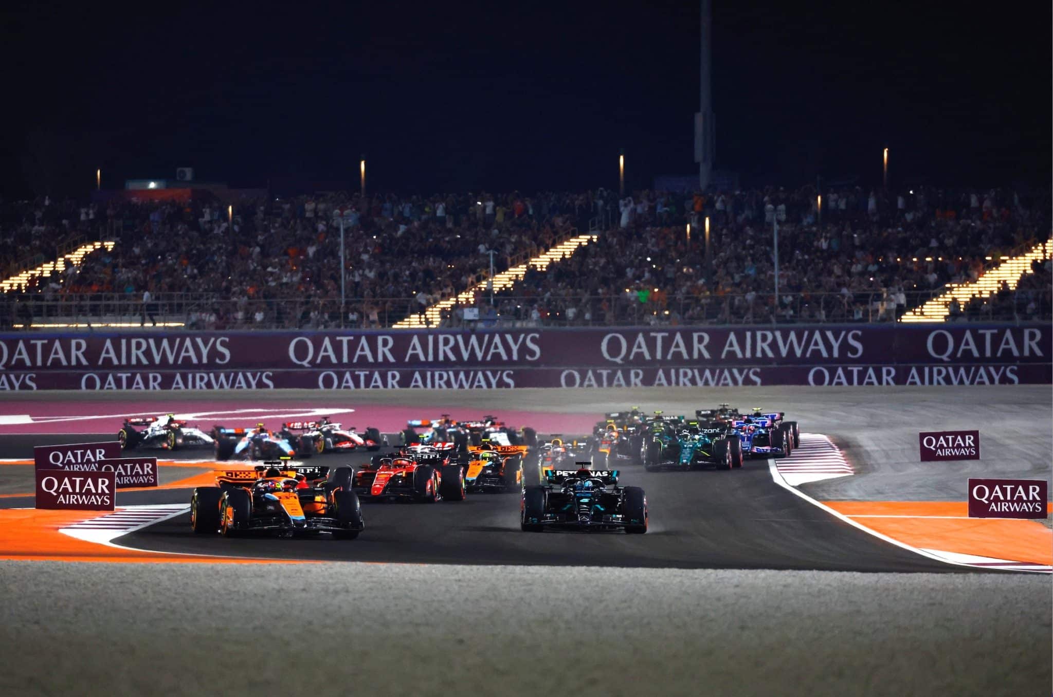 Formula 1 cars racing on the Lusail International Circuit where 'Qatar Airways' logo is shown on the stands