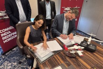 CEO's of Noemi Aerospace and SkyHop Aviation make sea plane deal. Both are sat down on a desk signing an agreement. They both look happy about the new achievement.
