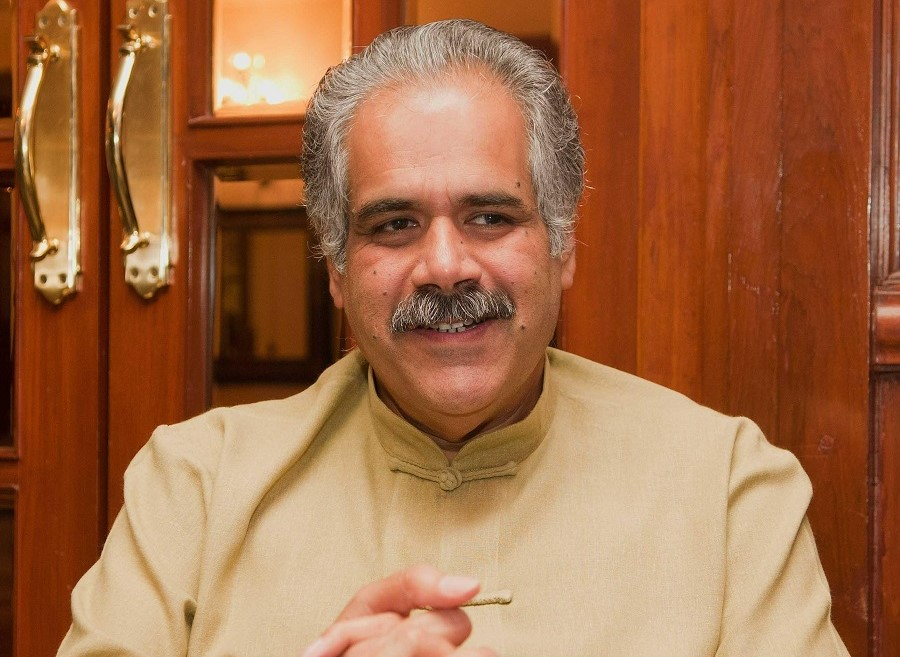 Photo of IndiGo Cofounder Rahul Bhatia smiling on front of a doorway.
