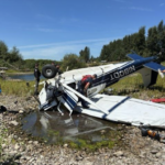 Picture of the crashed Cessna 180 with responders surrounding it.