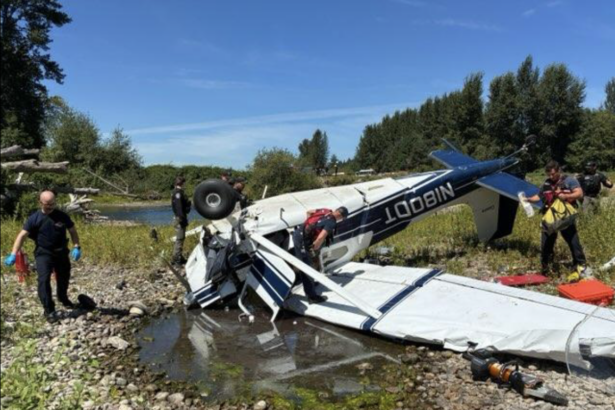 Picture of the crashed Cessna 180 with responders surrounding it.