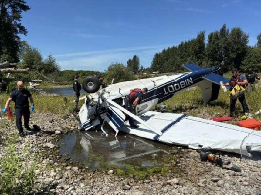 Picture of the crashed Cessna 180 with responders surrounding it.