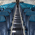 An image of WestJet's narrowbody cabin refresh with the iconic teal and navy blue seats.