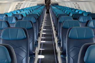 An image of WestJet's narrowbody cabin refresh with the iconic teal and navy blue seats.