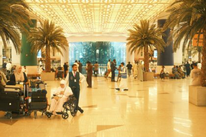 Saudia Arabia airport with palm trees and people sitting