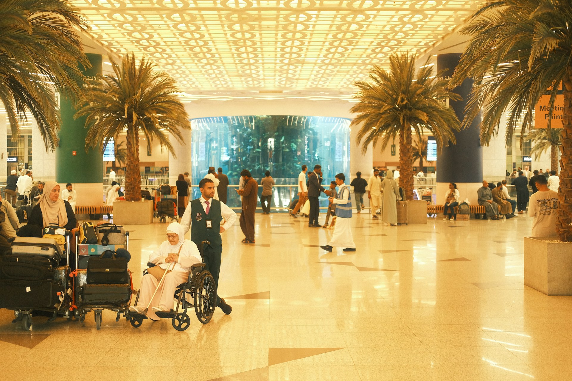 Saudia Arabia airport with palm trees and people sitting