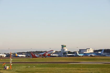 An image of Bristol Airport tarmac surrounded by green grass with various EasyJet planes seen on the runway and a clear bright blue sky backdrop.