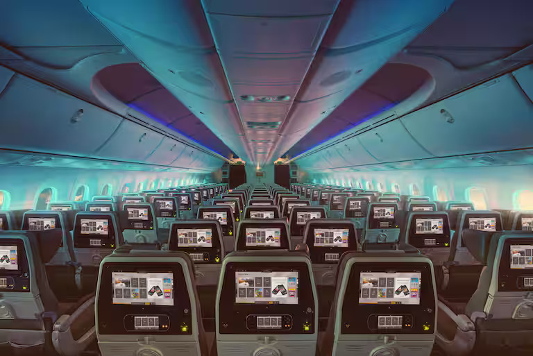 Photograph depicting in-flight entertainment screens in Etihad's Economy Class cabin, highlighting the physical interior of the aircraft cabin.