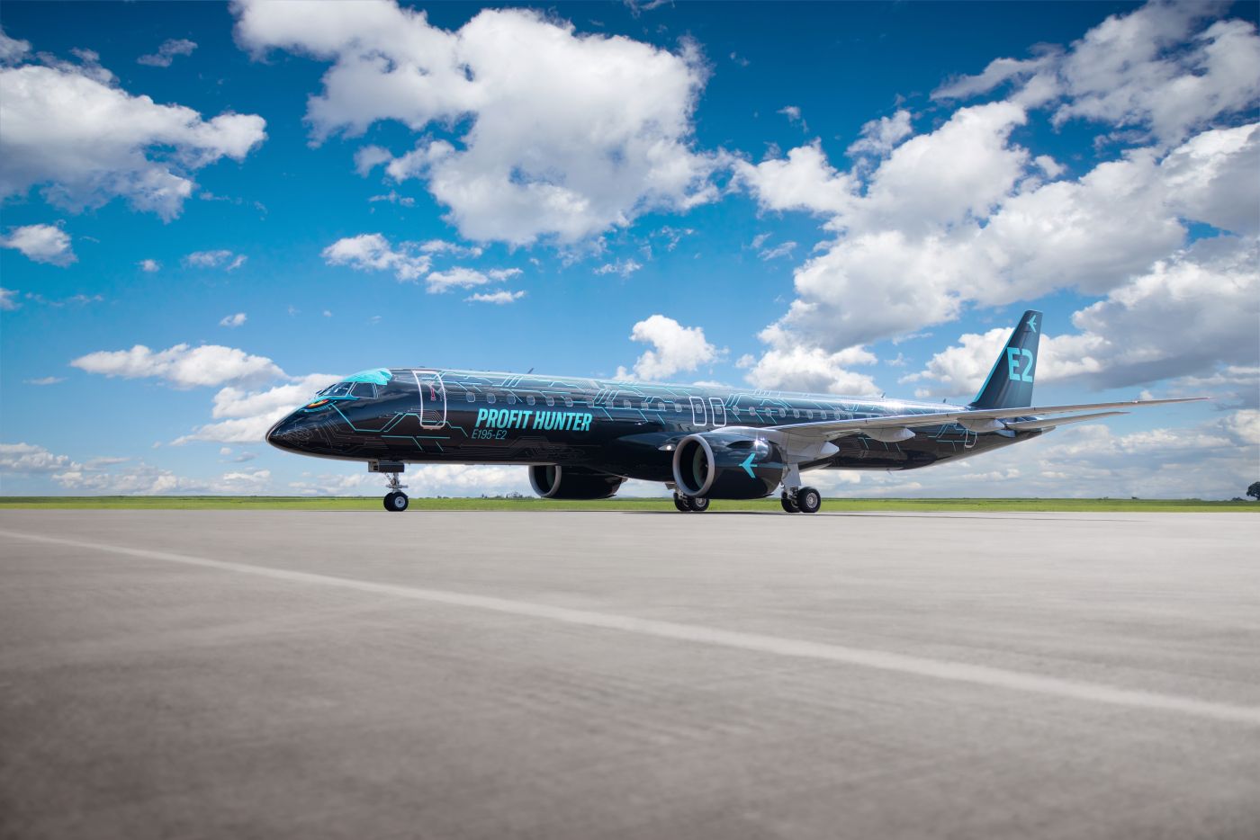 A black Embraer E195-E2 in 'Tech Eagle' marketing demonstration, showing eagle eyes drawn on the cockpit and parked on tarmac with a clear blue sky background