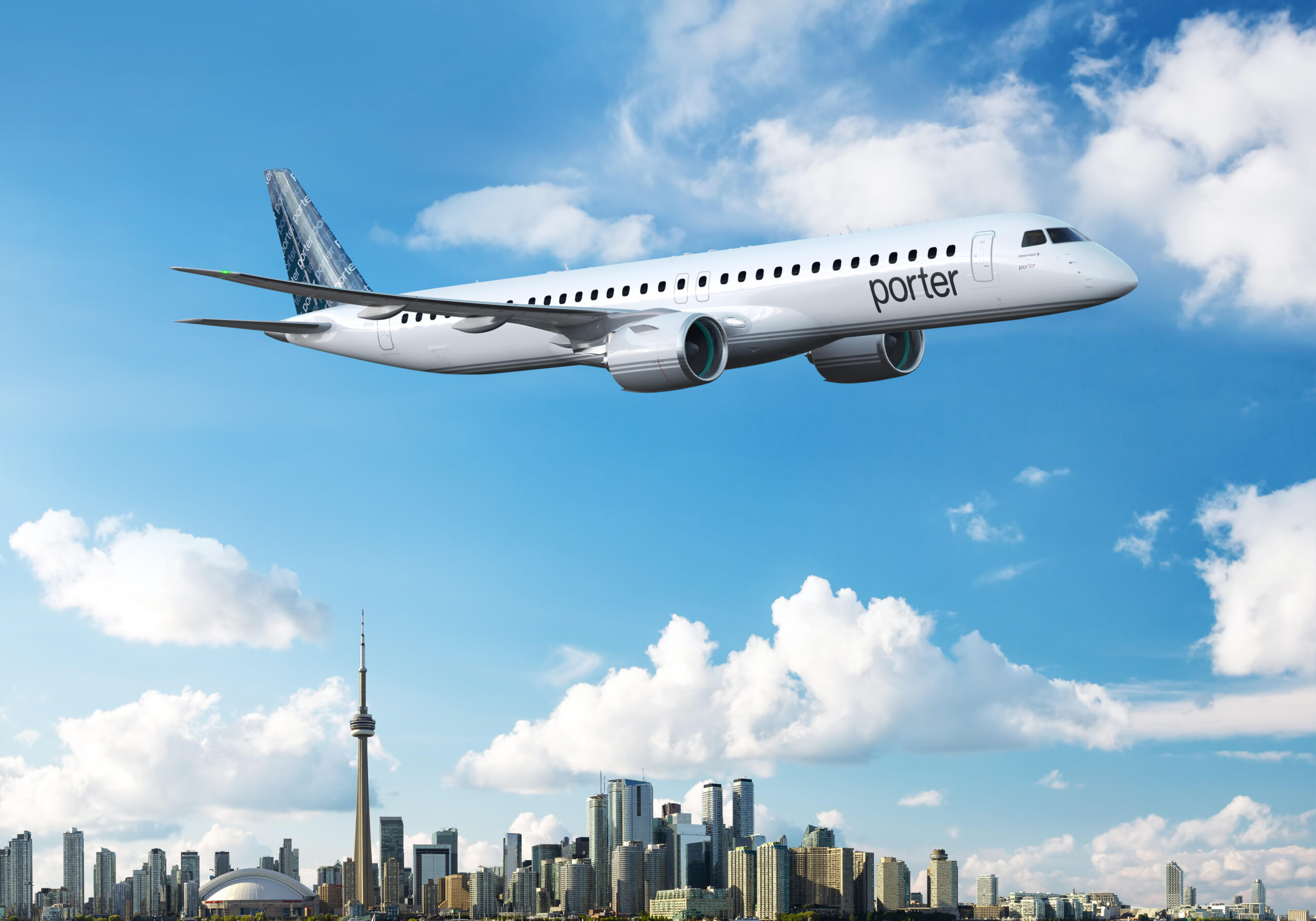 A Porter Airlines Embraer E195-E2 flying under a blue sky with some clouds over the Toronto skyline. 