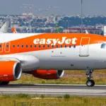 EasyJet plane waiting to takeoff on an airport runny on a sunny hazy day.