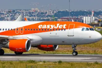 EasyJet plane waiting to takeoff on an airport runny on a sunny hazy day.