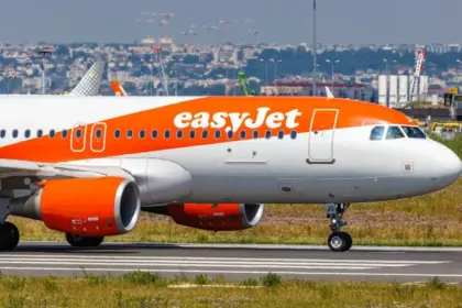 EasyJet plane waiting to takeoff on an airport runny on a sunny hazy day.