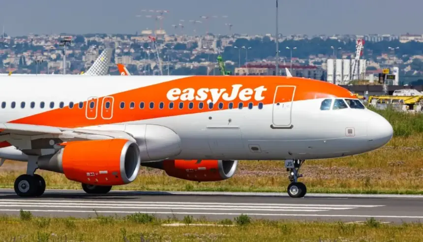 EasyJet plane waiting to takeoff on an airport runny on a sunny hazy day.