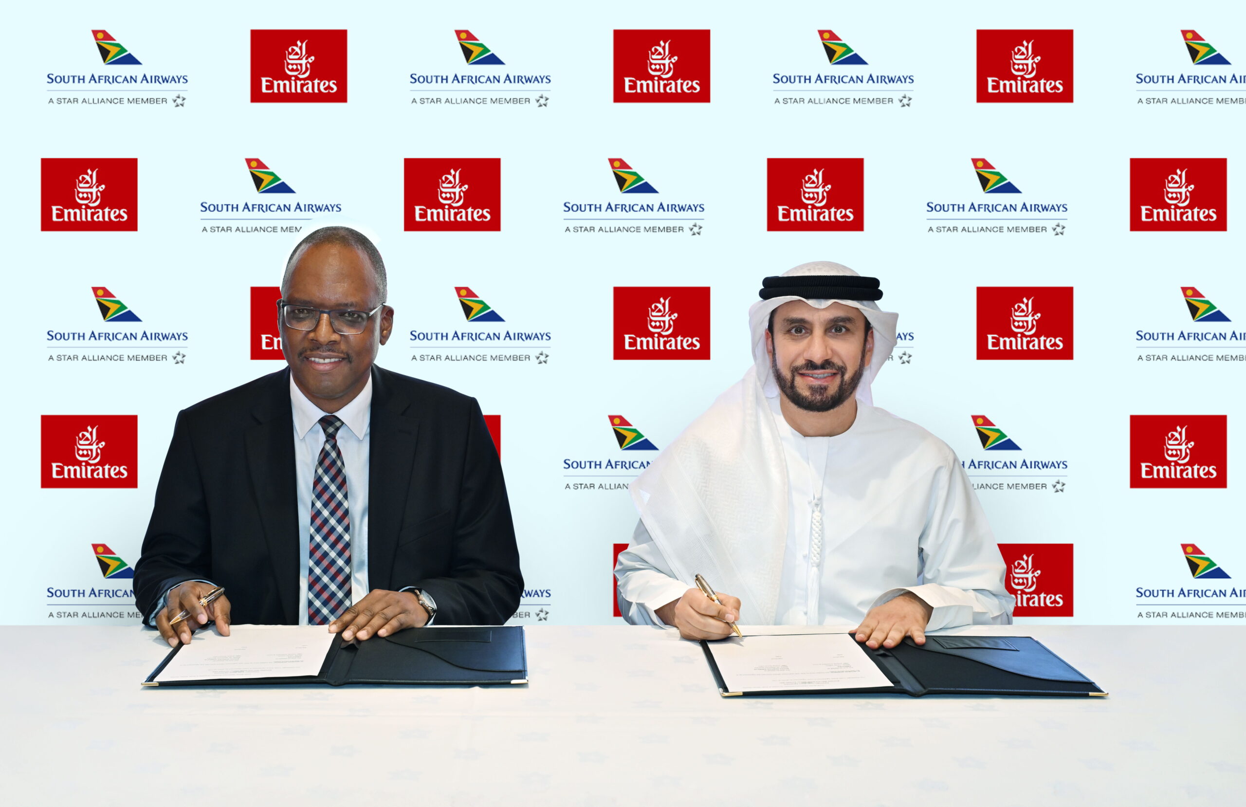 Photograph depicting senior officers from South African Airways and Emirates facing the media after signing an agreement.