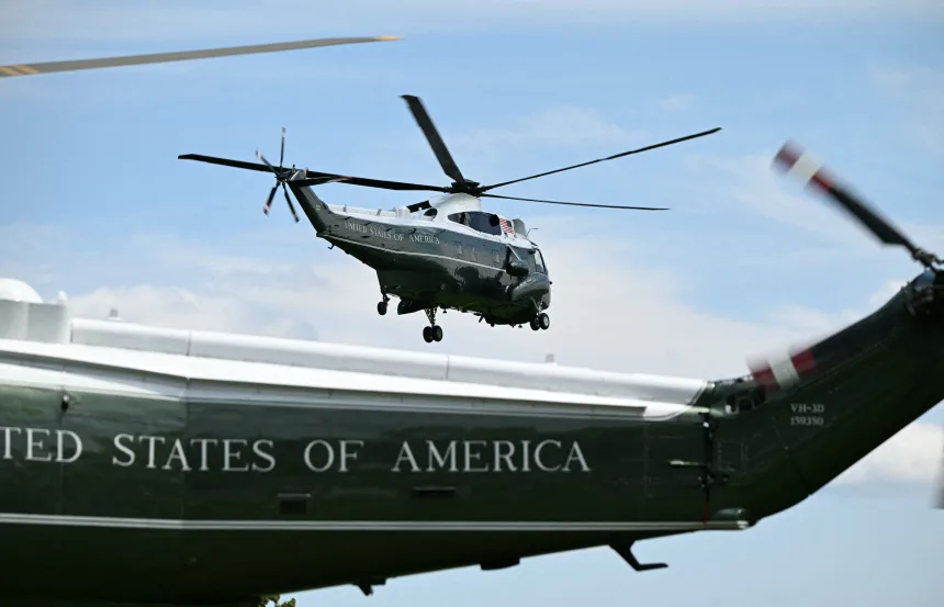 Tail of a Trump's Marine One and another helicopter flying behind it.